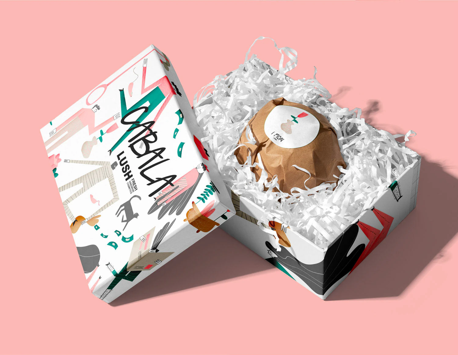 An open gift box with a bath bomb wrapped in paper, on pink.