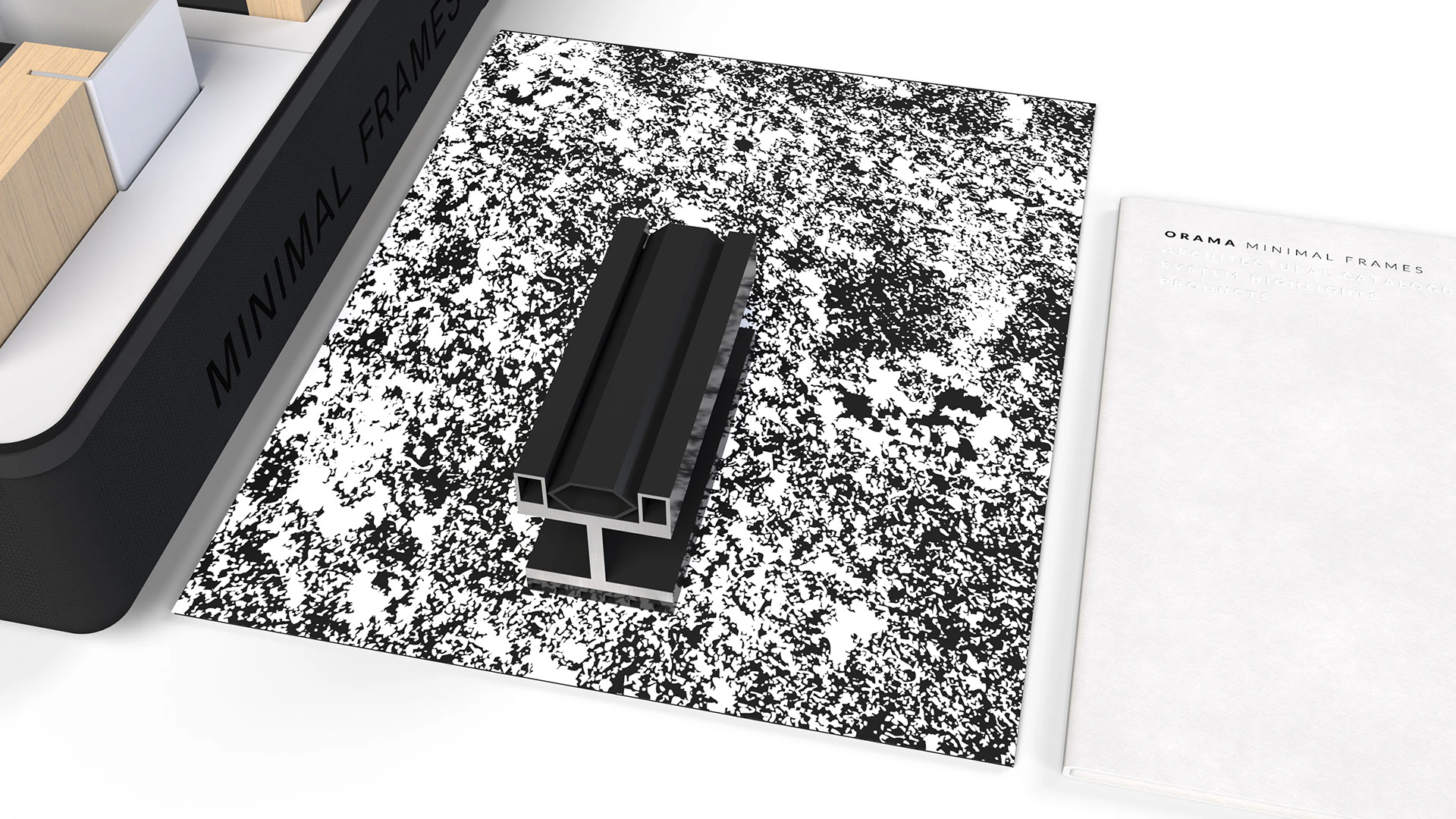 A frame profile sample on the patterned mat, beside the technical book.
