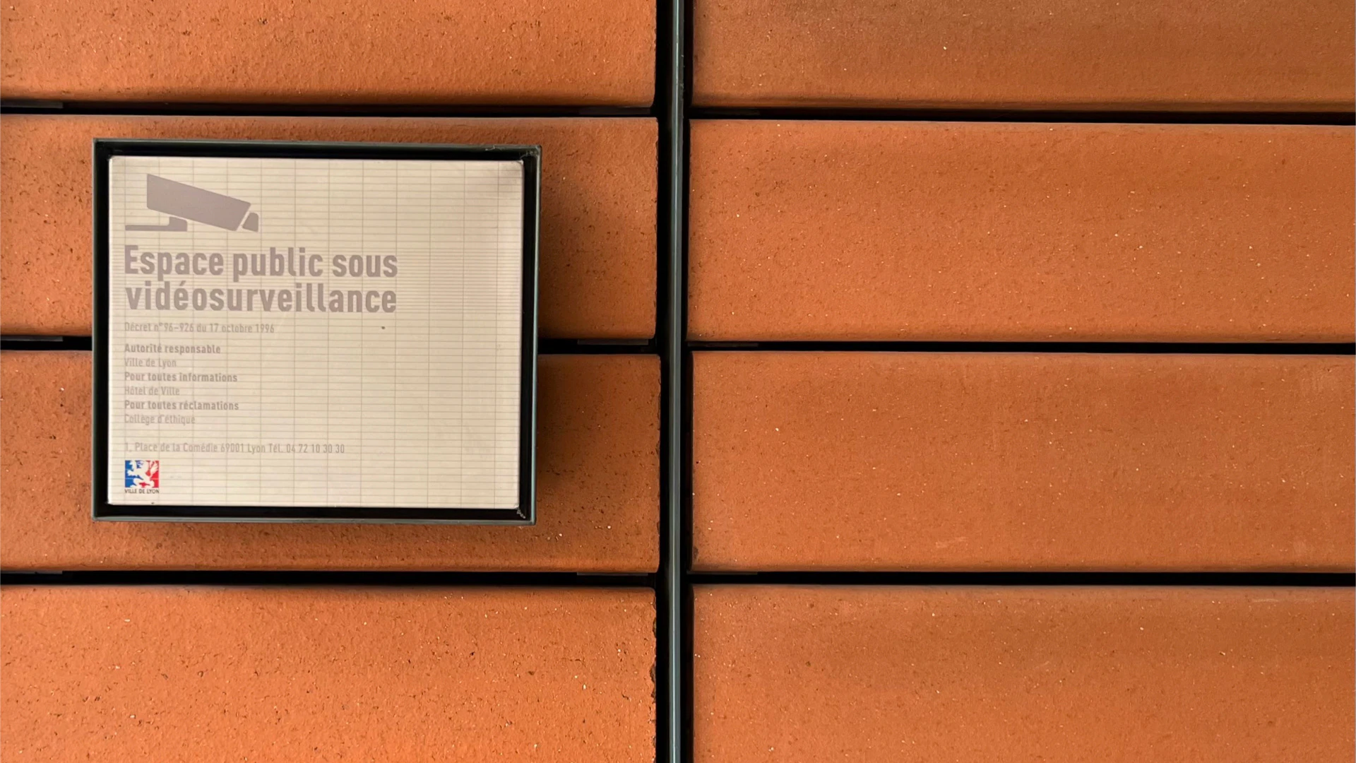 A small information plaque on an orange façade of the Cité Internationale.