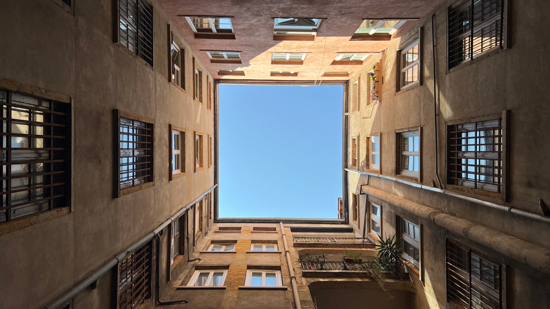 Looking up from a tall traboule courtyard.