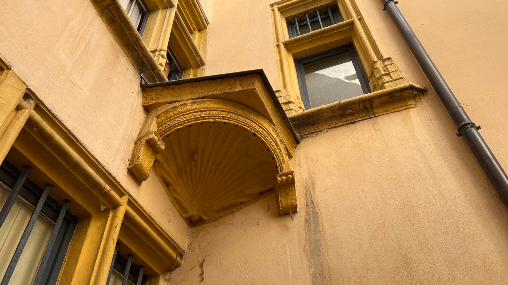 Ochre façades and a balcony in a traboule courtyard.