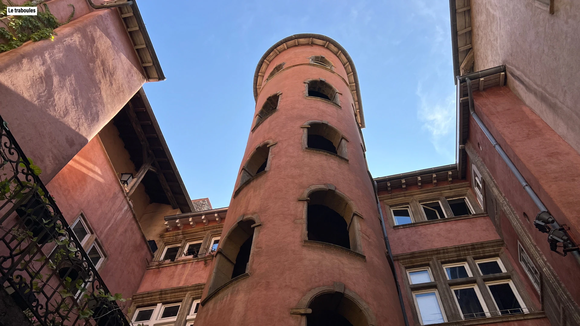 A round stair tower in a red traboule courtyard.