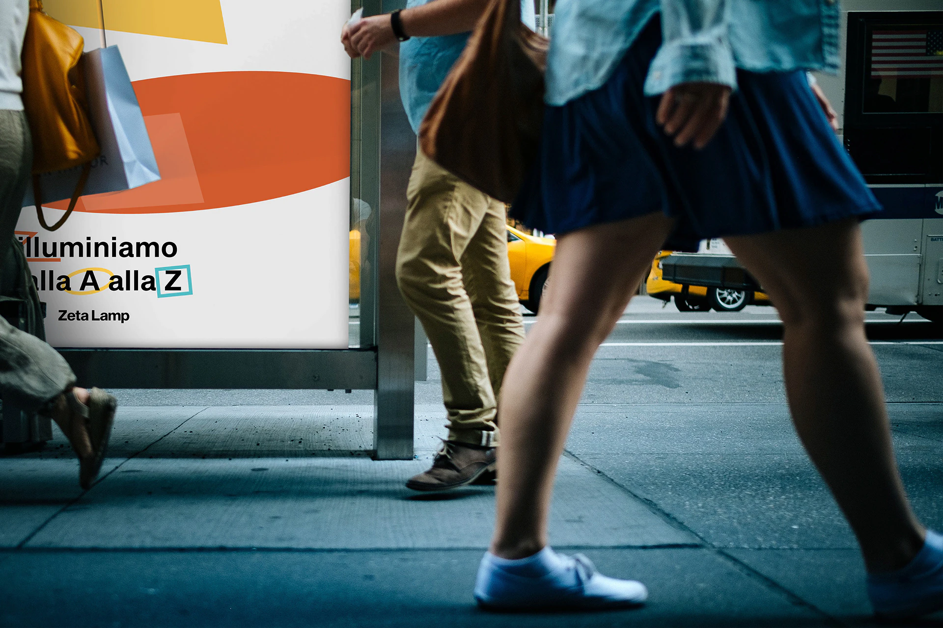 The poster at a bus stop, with people walking past.